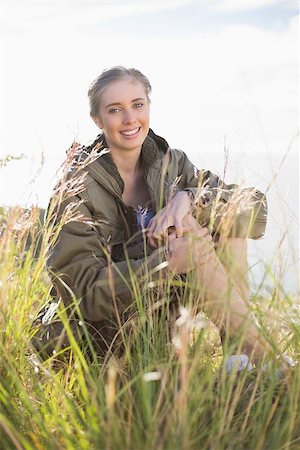 simsearch:400-06956627,k - Woman sitting in grass looking and smiling at camera in the countryside Stock Photo - Budget Royalty-Free & Subscription, Code: 400-06956533