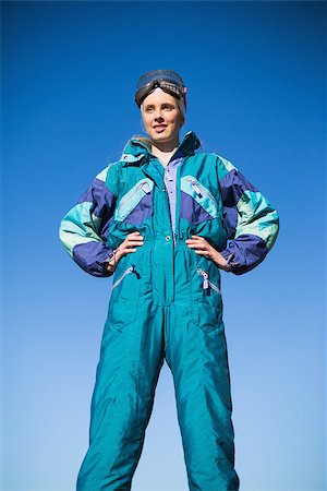 Woman wearing ski suit with hands on hips with blue sky behind Foto de stock - Super Valor sin royalties y Suscripción, Código: 400-06956645