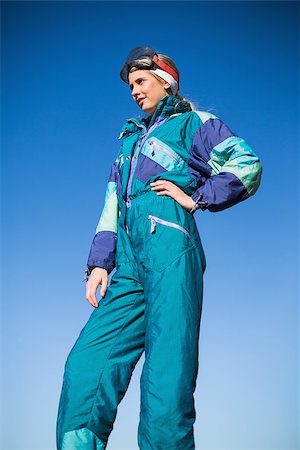 Woman in ski suit with one hand on hip looking away with blue sky behind Stock Photo - Budget Royalty-Free & Subscription, Code: 400-06956648