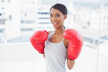 picture of women wearing boxing - Competitive smiling model wearing red boxing gloves in bright room at home Stock Photo - Budget Royalty-Free & Subscription, Code: 400-06956923