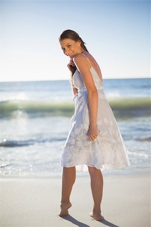 Smiling attractive woman on the beach looking over shoulder at camera Stock Photo - Budget Royalty-Free & Subscription, Code: 400-06957725