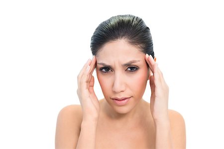 Frowning brunette with a headache touching her temples on white background Stock Photo - Budget Royalty-Free & Subscription, Code: 400-06957948