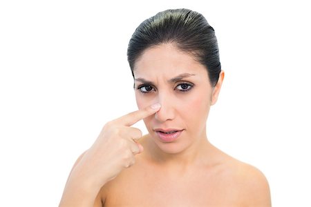 simsearch:400-06960125,k - Worried brunette pointing to nose and looking at camera on white background Photographie de stock - Aubaine LD & Abonnement, Code: 400-06957955