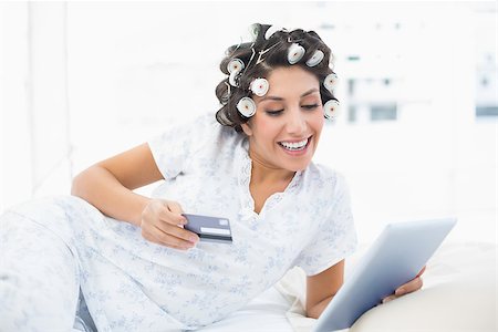 simsearch:693-06120730,k - Smiling brunette in hair rollers lying on her bed using her tablet to shop online in bedroom at home Foto de stock - Super Valor sin royalties y Suscripción, Código: 400-06958238