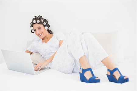 simsearch:693-06323945,k - Brunette in hair rollers and wedge shoes using her laptop on bed in bedroom at home Stock Photo - Budget Royalty-Free & Subscription, Code: 400-06958257