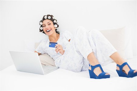 simsearch:693-06323945,k - Brunette in hair rollers and wedge shoes using her laptop to shop online in bedroom at home Stock Photo - Budget Royalty-Free & Subscription, Code: 400-06958261