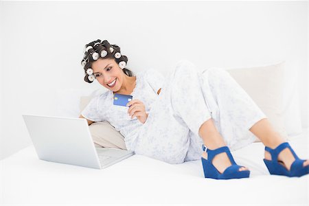 simsearch:693-06323945,k - Brunette in hair rollers and wedge shoes using her laptop for shopping online in bedroom at home Stock Photo - Budget Royalty-Free & Subscription, Code: 400-06958262