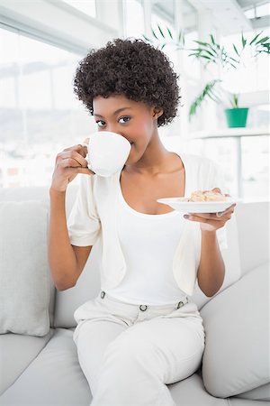 salon de coiffure - Smiling pretty brunette drinking coffee sitting on cosy sofa Foto de stock - Super Valor sin royalties y Suscripción, Código: 400-06959361