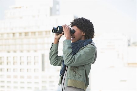 simsearch:400-08430017,k - Cheerful casual model looking through binoculars outdoors on a sunny day Stock Photo - Budget Royalty-Free & Subscription, Code: 400-06959426