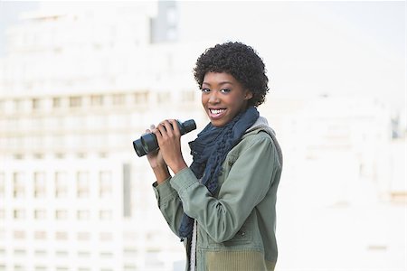 simsearch:400-08430017,k - Smiling casual model holding binoculars outdoors on a sunny day Stock Photo - Budget Royalty-Free & Subscription, Code: 400-06959428