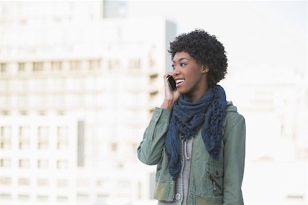 simsearch:400-08430017,k - Smiling casual model on the phone looking away outdoors on a sunny day Stock Photo - Budget Royalty-Free & Subscription, Code: 400-06959435