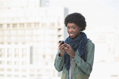 simsearch:400-08430017,k - Cheerful afro model texting outdoors on a sunny day Stock Photo - Budget Royalty-Free & Subscription, Code: 400-06959437