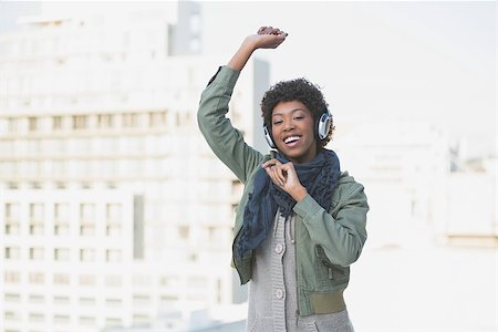 simsearch:400-08430017,k - Cheerful casual model dancing while listening to music outdoors on a sunny day Stock Photo - Budget Royalty-Free & Subscription, Code: 400-06959431