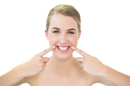 shoulder rides - Pretty blonde pointing at mouth wrinkle while posing on white background Photographie de stock - Aubaine LD & Abonnement, Code: 400-06959508