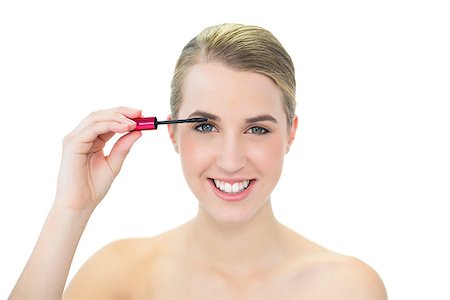 simsearch:400-05734913,k - Cheerful attractive blonde on white background applying mascara Foto de stock - Royalty-Free Super Valor e Assinatura, Número: 400-06959538