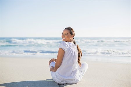 Rear view of smiling woman on the beach  on a sunny day looking over shoulder at camera Stock Photo - Budget Royalty-Free & Subscription, Code: 400-06959874