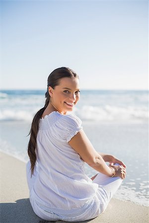 Rear view of smiling woman on the beach on a sunny day looking over shoulder at camera Stock Photo - Budget Royalty-Free & Subscription, Code: 400-06959875