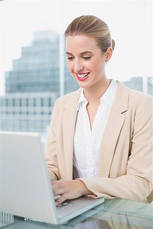 simsearch:400-05663929,k - Smiling businesswoman working on her laptop in bright office Stock Photo - Budget Royalty-Free & Subscription, Code: 400-06959995