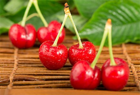 simsearch:400-06855989,k - Cherries and branch with leaves. Studio shot Photographie de stock - Aubaine LD & Abonnement, Code: 400-06950368