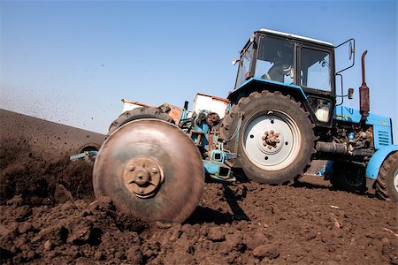 simsearch:400-05041805,k - Blue tractor with sower on the field in bright sunny spring morning Stock Photo - Budget Royalty-Free & Subscription, Code: 400-06950779