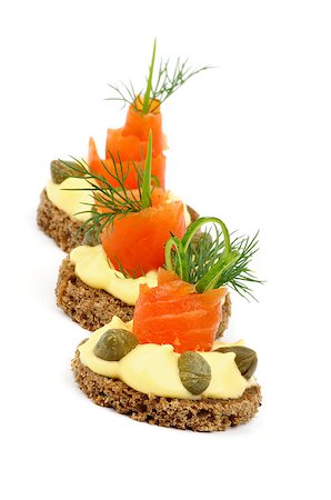 simsearch:400-07039898,k - Three Delicious Snacks with Smoked Salmon, Greens, Cheese Cream and Capers In a Row isolated on white background Foto de stock - Royalty-Free Super Valor e Assinatura, Número: 400-06950929