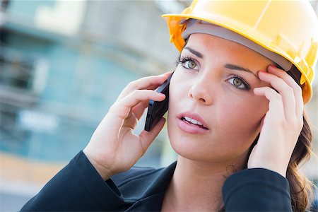 Young Worried Looking Professional Female Contractor Wearing Hard Hat at Construction Site Using Cell Phone. Stock Photo - Budget Royalty-Free & Subscription, Code: 400-06951139