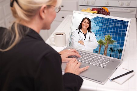 simsearch:400-05129327,k - Over Shoulder of Woman In Kitchen Using Laptop - Online Chat with Nurse or Doctor on Screen. Stock Photo - Budget Royalty-Free & Subscription, Code: 400-06951297
