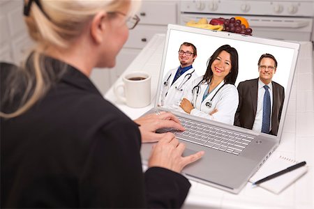 simsearch:400-06857713,k - Over Shoulder of Woman In Kitchen Using Laptop Online Chat with Nurses or Doctors on Screen. Fotografie stock - Microstock e Abbonamento, Codice: 400-06951299