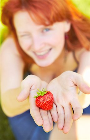 food market many people - beautiful girl holding a strawberry, focus on the berries Stock Photo - Budget Royalty-Free & Subscription, Code: 400-06951489