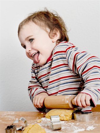 cute, laughing child with dough and rolling ping grey background. horizontal image Foto de stock - Royalty-Free Super Valor e Assinatura, Número: 400-06951773
