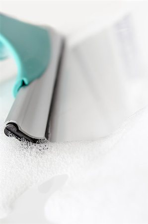 Detail of cleaning white ceramic tiles with rubber window cleaner. Stockbilder - Microstock & Abonnement, Bildnummer: 400-06951962