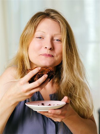 Photo of a beautiful blond woman in her early thirties with log blond hair eating a large piece of brownie or cake. Stock Photo - Budget Royalty-Free & Subscription, Code: 400-06952518