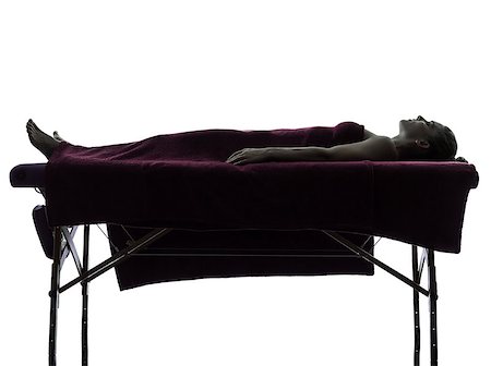 full body massage - one woman lying on a massage table in silhouette studio on white background Foto de stock - Super Valor sin royalties y Suscripción, Código: 400-06953355