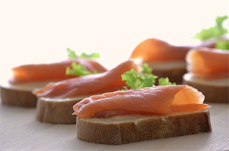 simsearch:400-05881424,k - Canapes with smoked salmon, butter and lettuce leaf. Shallow dof. Stockbilder - Microstock & Abonnement, Bildnummer: 400-06953480