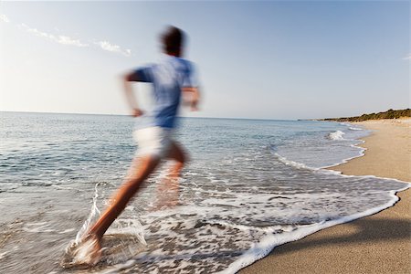 rcaucino (artist) - Athletic caucasian man running barefoot on the border of the sea in a deserted tropical beach. Light blue shirt and white shorts. Motion blur effect. Photographie de stock - Aubaine LD & Abonnement, Code: 400-06953580