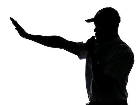 pictures of traffic police man - An afro American traffic cop making stop gesture while blowing whistle in studio on white isolated background Stock Photo - Budget Royalty-Free & Subscription, Code: 400-06953815