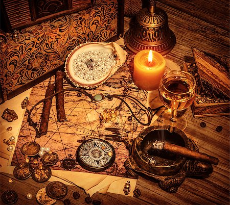 Closeup on beautiful buccaneer treasure background, luxury pirates alcohol drink, cigars, compass, pearl beads, drawing map, piracy lifestyle concept Stock Photo - Budget Royalty-Free & Subscription, Code: 400-06953989