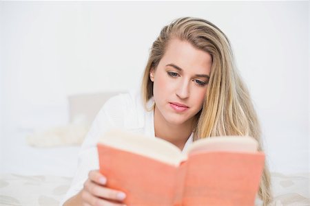 simsearch:693-07542343,k - Relaxed gorgeous model lying on cosy bed in bright bedroom reading book Stock Photo - Budget Royalty-Free & Subscription, Code: 400-06960006