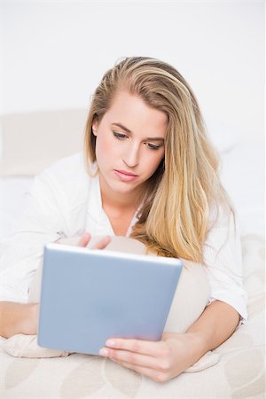 simsearch:693-07542343,k - Focused model using her tablet lying on cosy bed in bright bedroom Stock Photo - Budget Royalty-Free & Subscription, Code: 400-06960017