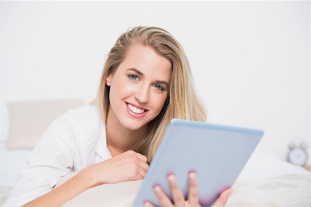 simsearch:693-07542343,k - Smiling pretty model using her tablet pc lying on cosy bed in bright bedroom Stock Photo - Budget Royalty-Free & Subscription, Code: 400-06960024