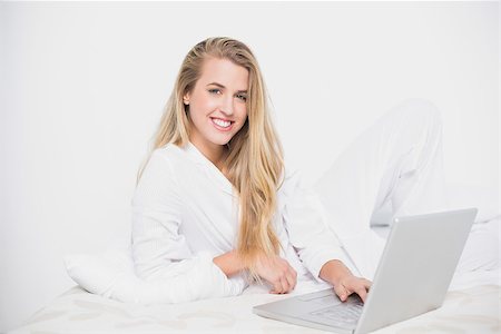 simsearch:693-07542343,k - Cheerful pretty model using her laptop lying on cosy bed in bright bedroom Stock Photo - Budget Royalty-Free & Subscription, Code: 400-06960026