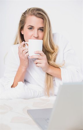 simsearch:693-07542343,k - Smiling pretty model drinking coffee lying on cosy bed in bright bedroom Stock Photo - Budget Royalty-Free & Subscription, Code: 400-06960030