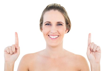 simsearch:400-06960125,k - Smiling blonde woman pointing up against white background Photographie de stock - Aubaine LD & Abonnement, Code: 400-06960060