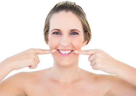 shoulder rides - Smiling woman on white background pointing at wrinkle on her mouth corners Photographie de stock - Aubaine LD & Abonnement, Code: 400-06960074