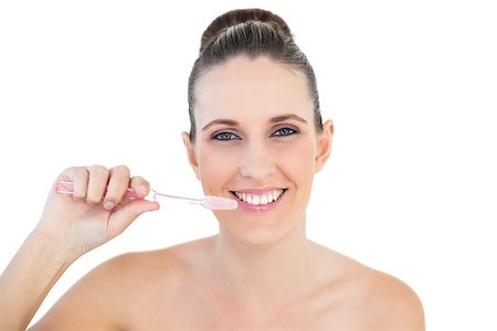 simsearch:400-06960125,k - Smiling pretty woman brushing her teeth on white background Photographie de stock - Aubaine LD & Abonnement, Code: 400-06960105