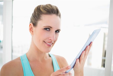 Smiling woman using tablet looking at camera Stock Photo - Budget Royalty-Free & Subscription, Code: 400-06960303