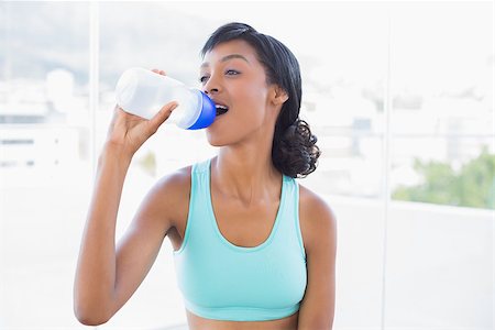 Content fit woman drinking a bottle of water in a living room Stock Photo - Budget Royalty-Free & Subscription, Code: 400-06960692