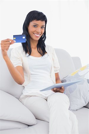 simsearch:400-07127374,k - Charming black haired woman buying online on her tablet pc in a living room Stock Photo - Budget Royalty-Free & Subscription, Code: 400-06960819