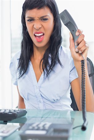 Exasperated businesswoman hanging up the phone in office Stock Photo - Budget Royalty-Free & Subscription, Code: 400-06960830