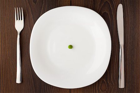 simsearch:400-07036577,k - One pea on a white plate with knife and fork Stock Photo - Budget Royalty-Free & Subscription, Code: 400-07035740